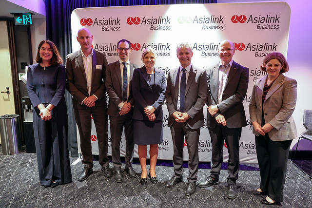 ACER CEO Lisa Rodgers with other participants in the Asialink event standing in front of a branded media wall
