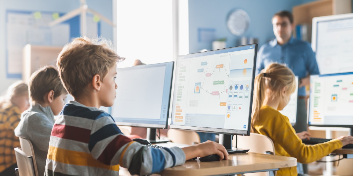 Elementary School Computer Science Classroom: Smart Little Schoolboy Work on Personal Computers, Learn Programming Language for Software Coding. Schoolchildren Getting Modern Education