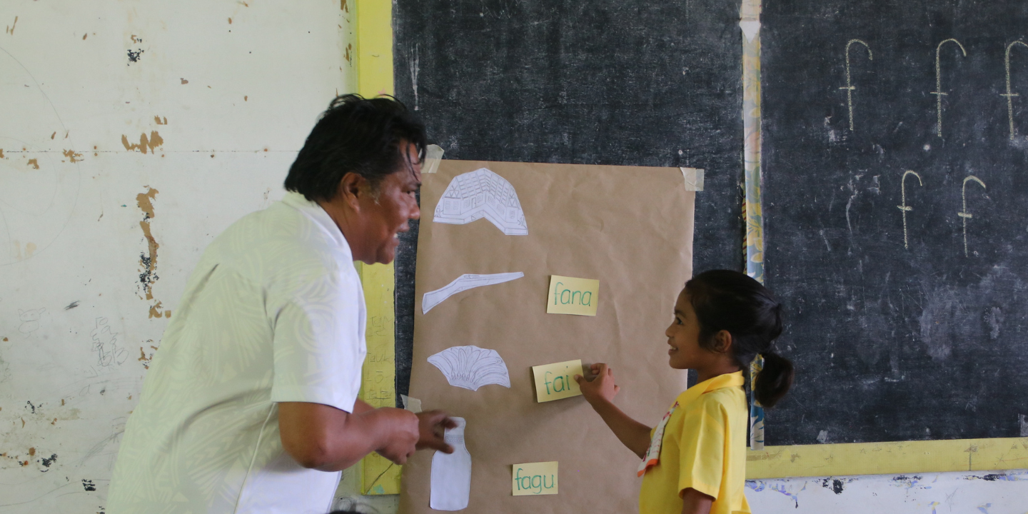 Teacher helps student with activity on board in the Pacific.