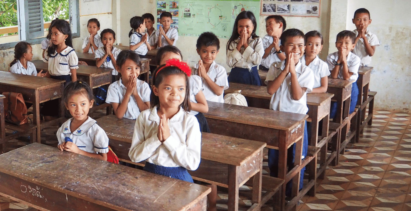 Stock image of primary school children in class looking and listening to their teacher