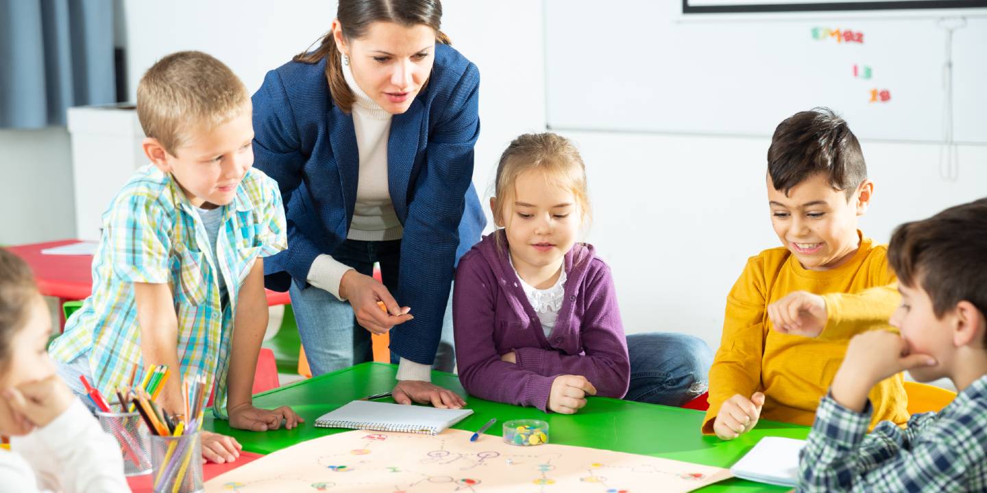 Children learning through play in school under supervision of teacher