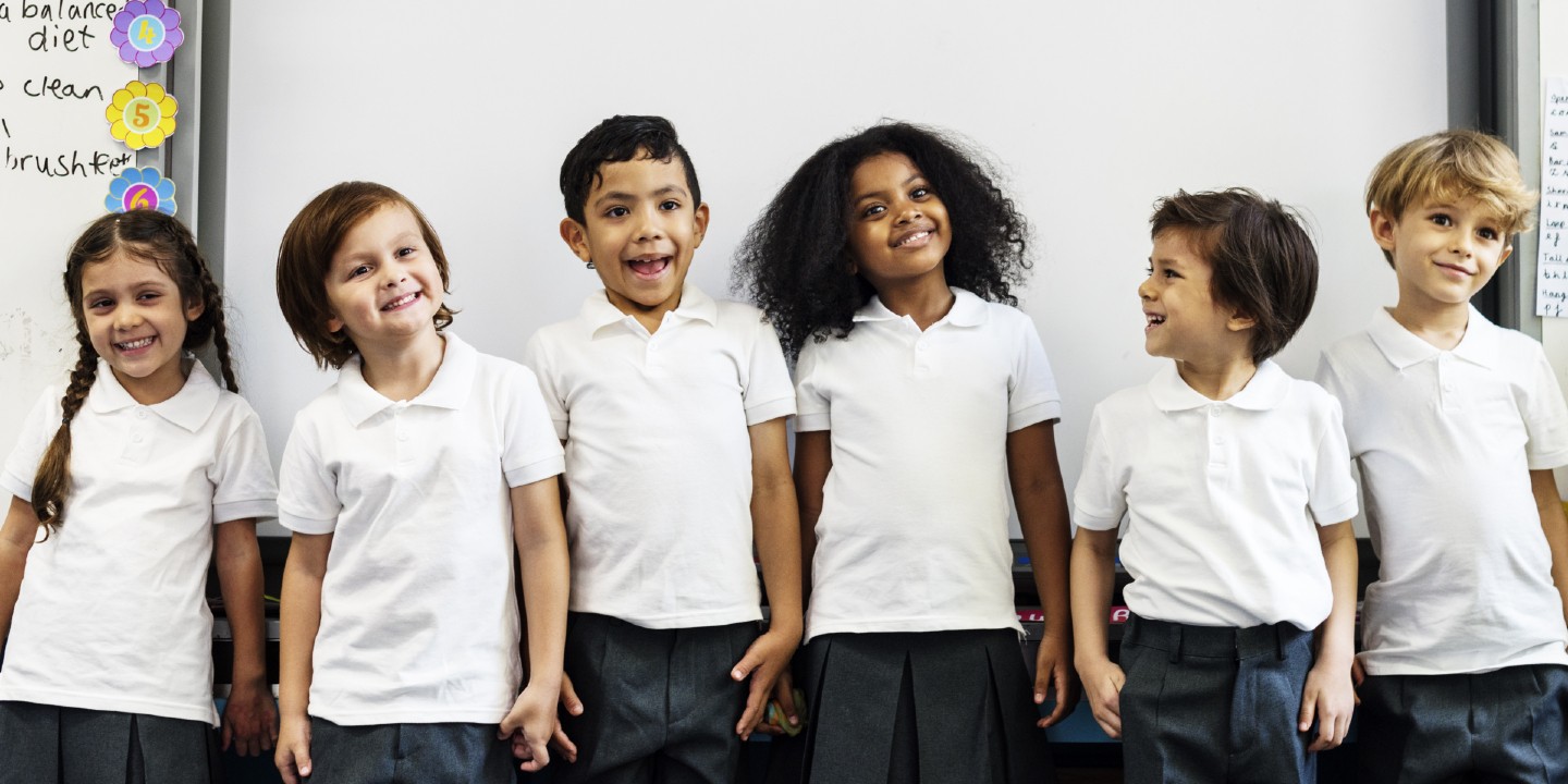Stock image of group of diverse primary school students standing together.